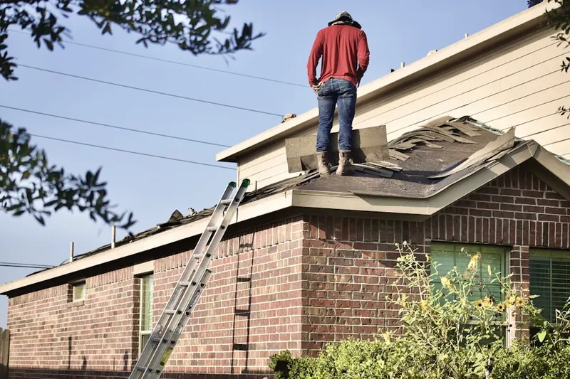 Professional roofer working on a residential roof in Emporia